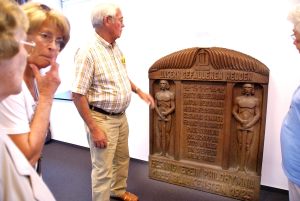 interessierte Besucher vor einer Ehrentafel